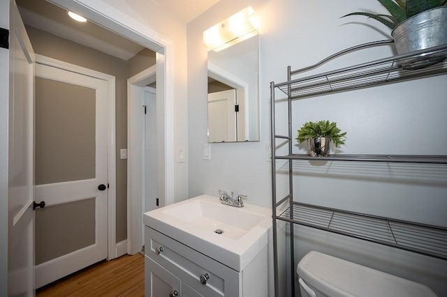 bathroom with vanity, hardwood / wood-style floors, and toilet