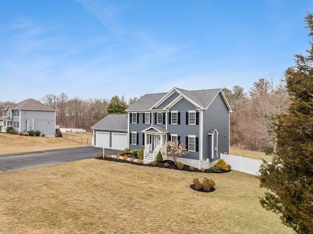 view of front of property with a garage, driveway, a front lawn, and fence