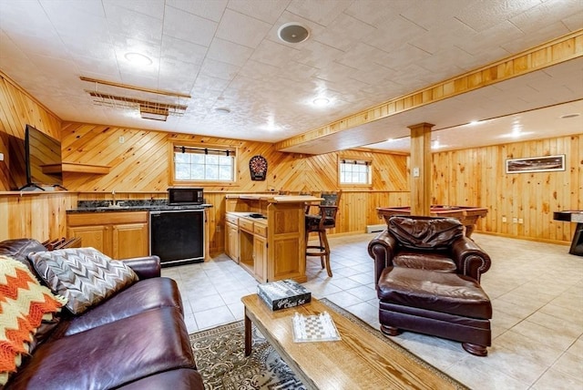 140 Sheffield Dr, Belchertown, MA 01007 - living room featuring wood walls, light tile patterned flooring, and bar area