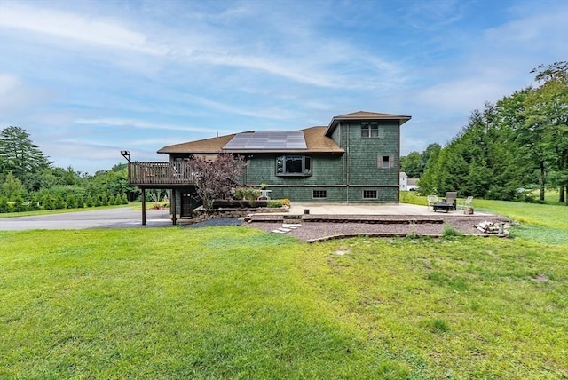 140 Sheffield Dr, Belchertown, MA 01007 - rear view of house with a deck, a patio, a lawn, and roof mounted solar panels