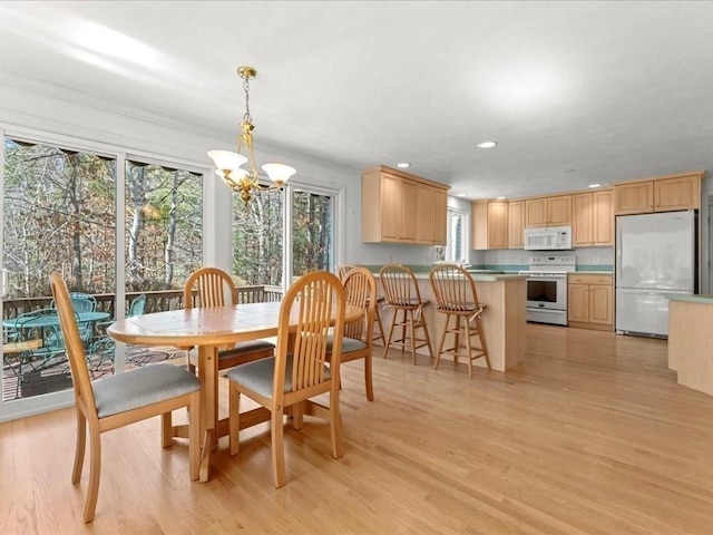 dining area featuring recessed lighting, light wood-style floors, and a chandelier