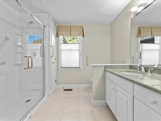 bathroom featuring tile patterned floors, toilet, a shower stall, and vanity