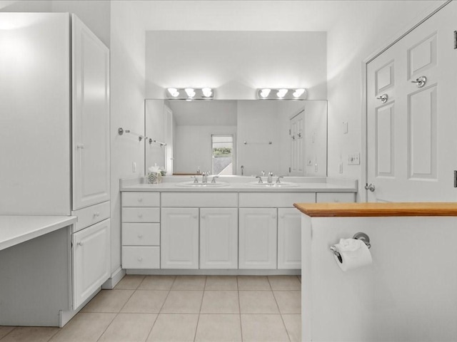 bathroom featuring a sink, double vanity, and tile patterned floors