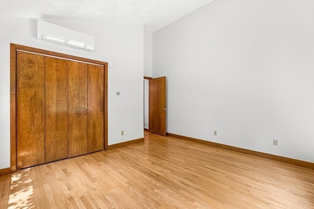 75 Winter St, Hopkinton, MA 01748 - unfurnished bedroom with a wall unit AC, light wood finished floors, and a closet