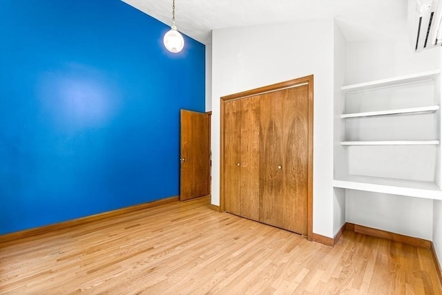 75 Winter St, Hopkinton, MA 01748 - unfurnished bedroom featuring wood finished floors, a closet, and a wall mounted AC
