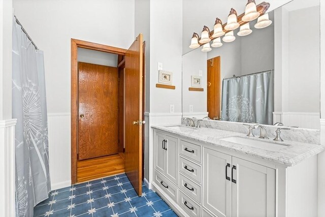 75 Winter St, Hopkinton, MA 01748 - full bath featuring wainscoting, double vanity, and tile patterned floors