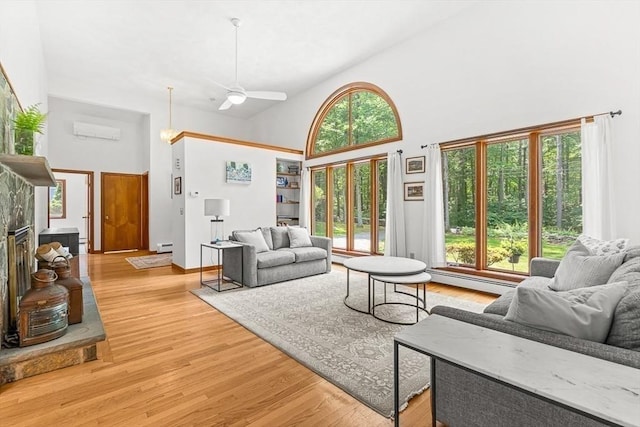 75 Winter St, Hopkinton, MA 01748 - living area with high vaulted ceiling, an AC wall unit, light wood-type flooring, ceiling fan, and a baseboard heating unit