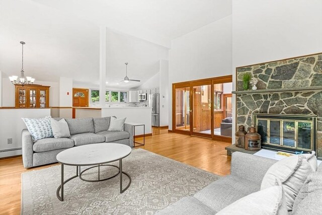 75 Winter St, Hopkinton, MA 01748 - living area featuring light wood-type flooring, high vaulted ceiling, ceiling fan, a fireplace, and a chandelier