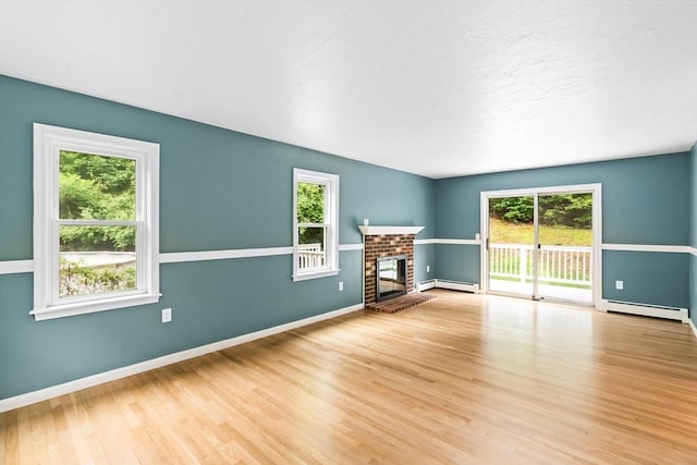 7 Evergreen Cir, Sterling, MA 01564 - unfurnished living room featuring a baseboard radiator, wood finished floors, and a brick fireplace