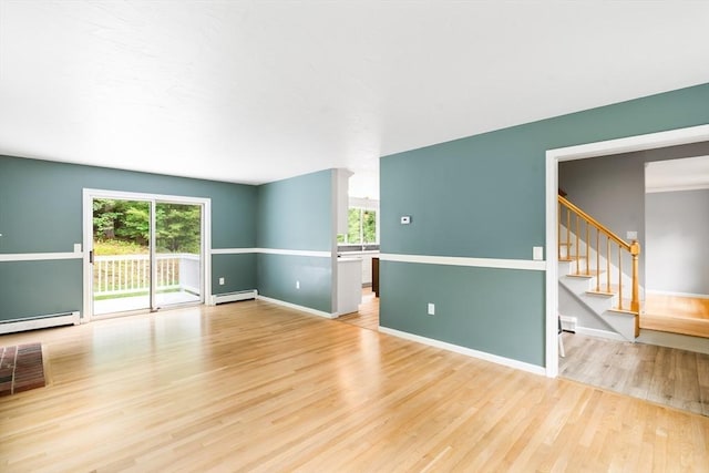7 Evergreen Cir, Sterling, MA 01564 - empty room with a baseboard heating unit, plenty of natural light, wood finished floors, and stairway