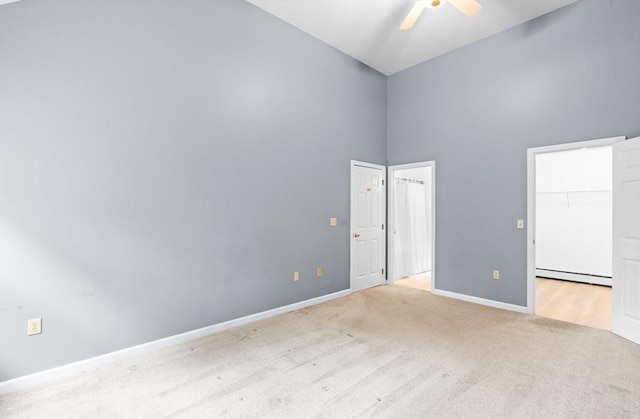 7 Evergreen Cir, Sterling, MA 01564 - unfurnished bedroom featuring carpet floors, baseboard heating, a towering ceiling, a spacious closet, and a ceiling fan