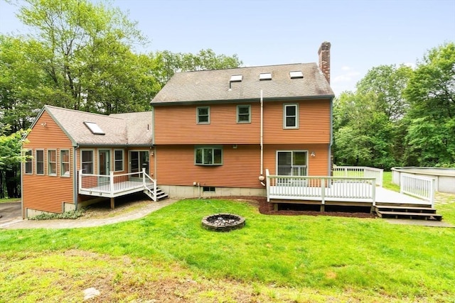 7 Evergreen Cir, Sterling, MA 01564 - back of house with a deck, a chimney, a lawn, a shingled roof, and an outdoor fire pit