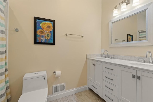 125 Heath St, Somerville, MA 02145 - bathroom featuring double vanity and wood finished floors