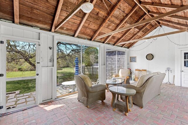 sunroom / solarium featuring lofted ceiling with beams and wooden ceiling