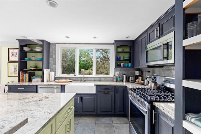 kitchen featuring sink, light tile patterned floors, appliances with stainless steel finishes, light stone counters, and tasteful backsplash