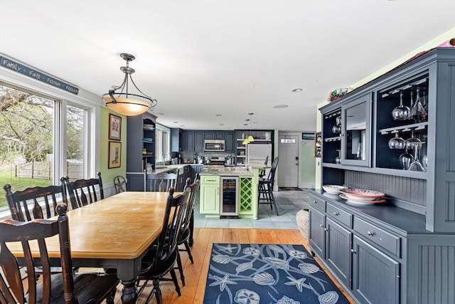 dining area with wine cooler and light hardwood / wood-style floors