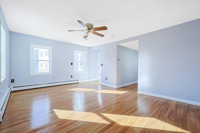 spare room with a baseboard radiator, ceiling fan, and light wood-type flooring