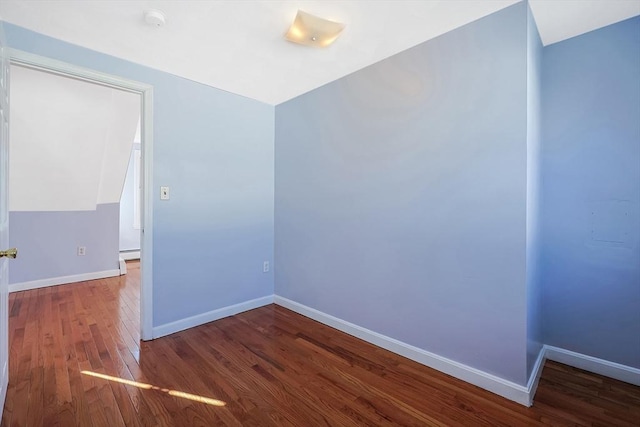 spare room with dark hardwood / wood-style flooring and baseboard heating