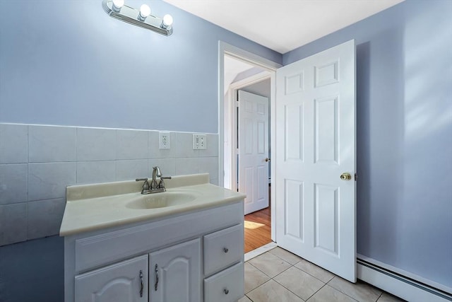 bathroom featuring tile walls, a baseboard heating unit, vanity, and tile patterned floors