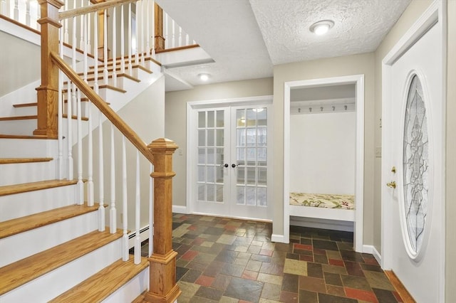 184 Burlingame Rd, Charlton, MA 01507 - mudroom with a baseboard heating unit, stone tile flooring, baseboards, a textured ceiling, and french doors