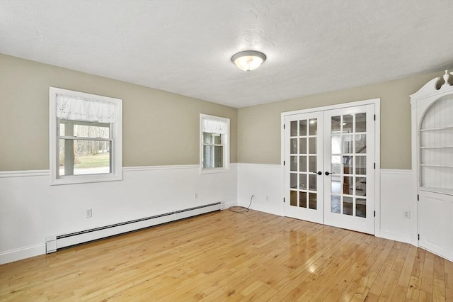 184 Burlingame Rd, Charlton, MA 01507 - empty room with a baseboard heating unit, hardwood / wood-style flooring, french doors, and a textured ceiling