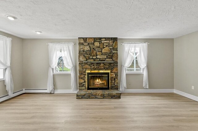 184 Burlingame Rd, Charlton, MA 01507 - unfurnished living room featuring baseboards, wood finished floors, a textured ceiling, and a fireplace