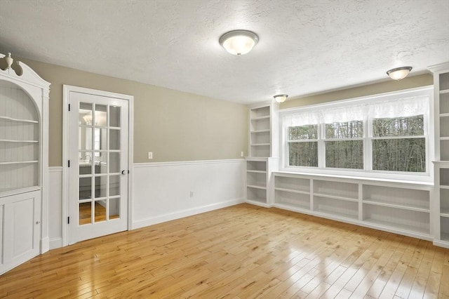 184 Burlingame Rd, Charlton, MA 01507 - unfurnished room with built in shelves, a textured ceiling, and hardwood / wood-style flooring