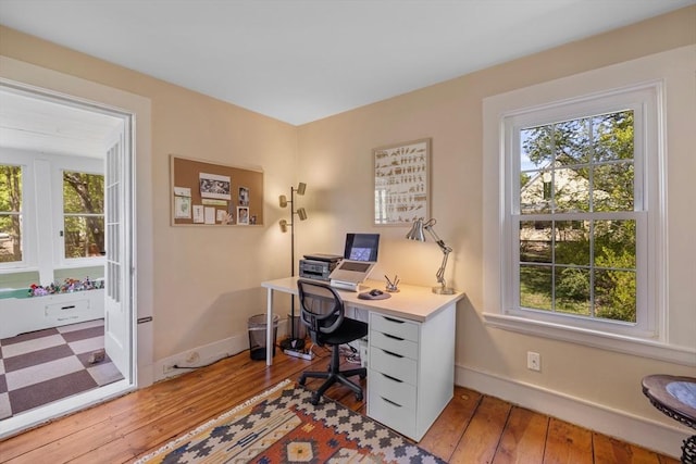 office area featuring light wood finished floors and baseboards