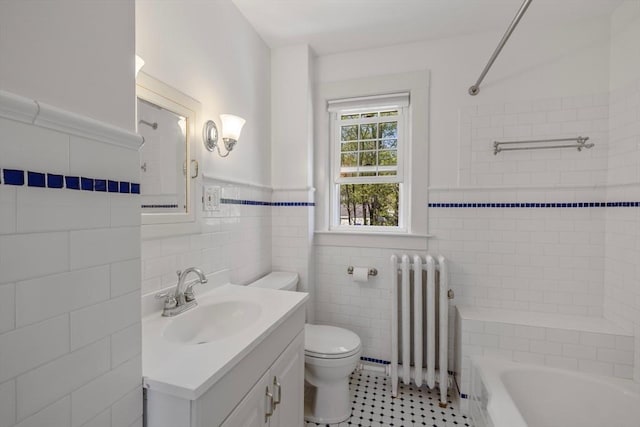 bathroom with radiator, tile walls, toilet, vanity, and tile patterned flooring
