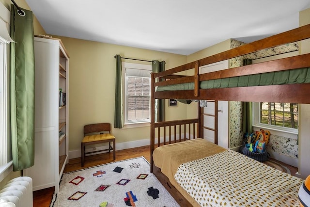bedroom featuring radiator, wood finished floors, and baseboards