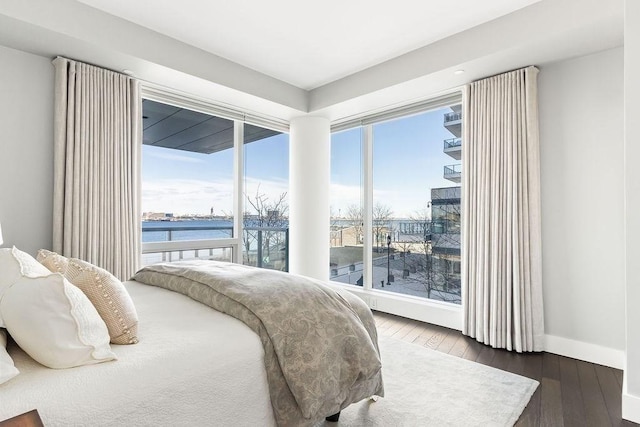 bedroom with hardwood / wood-style floors and baseboards