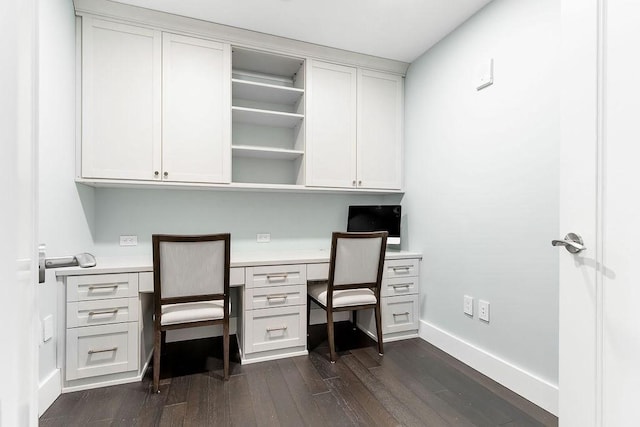 office space with built in study area, dark wood-type flooring, and baseboards