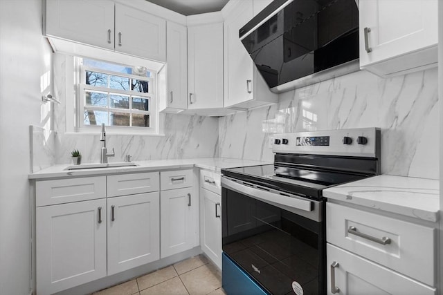 kitchen with exhaust hood, sink, light tile patterned floors, white cabinets, and stainless steel electric range