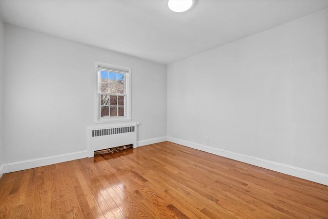 spare room with radiator and hardwood / wood-style flooring