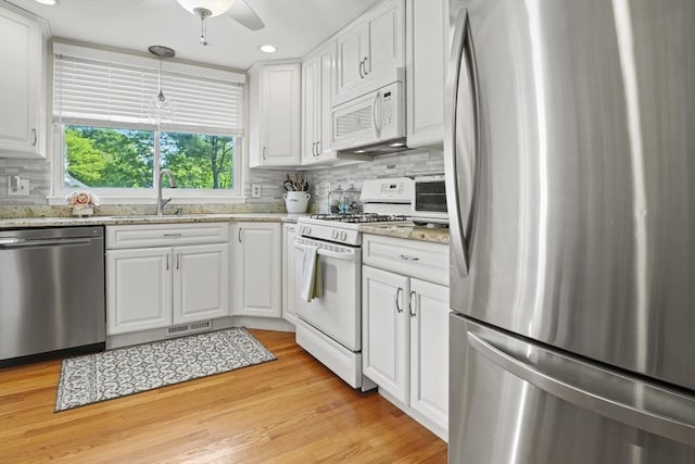 26 Gaslight Ln Unit 26, Easton, MA 02356 - kitchen with stainless steel appliances, a sink, white cabinets, backsplash, and light stone countertops