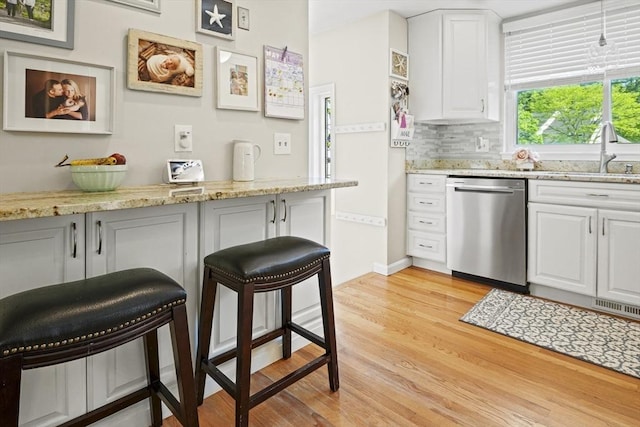 26 Gaslight Ln Unit 26, Easton, MA 02356 - kitchen with dishwasher, a sink, a kitchen breakfast bar, light wood-type flooring, and white cabinets