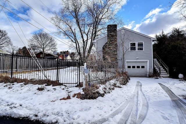 view of snowy exterior with a garage