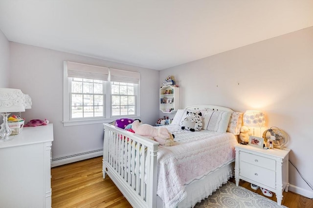 bedroom featuring light wood-type flooring and a baseboard radiator