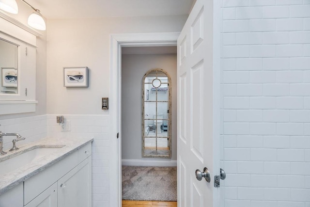 bathroom featuring wainscoting, vanity, and tile walls