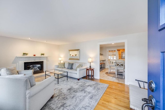 living room with a fireplace and light wood-type flooring