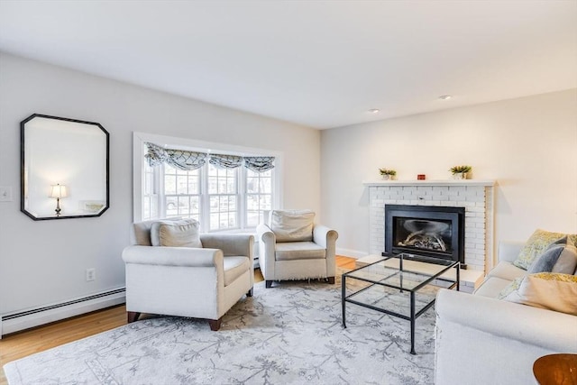 living area featuring a brick fireplace, wood finished floors, and a baseboard radiator