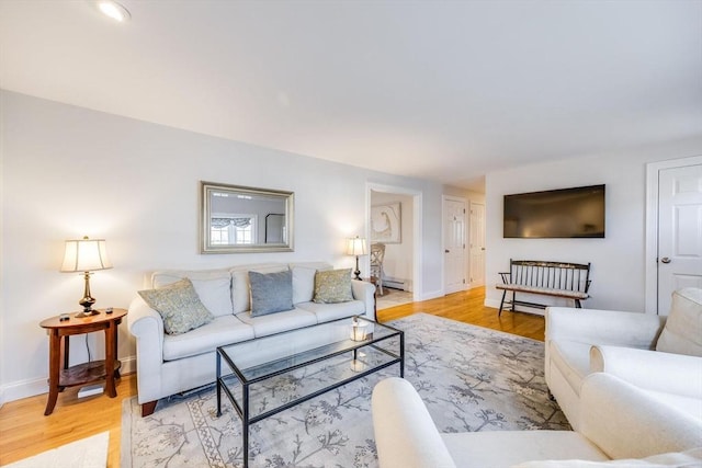 living area featuring baseboards and light wood finished floors