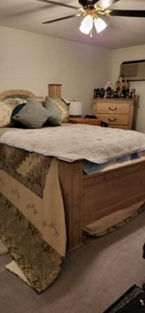 carpeted bedroom with ceiling fan and a wall mounted AC