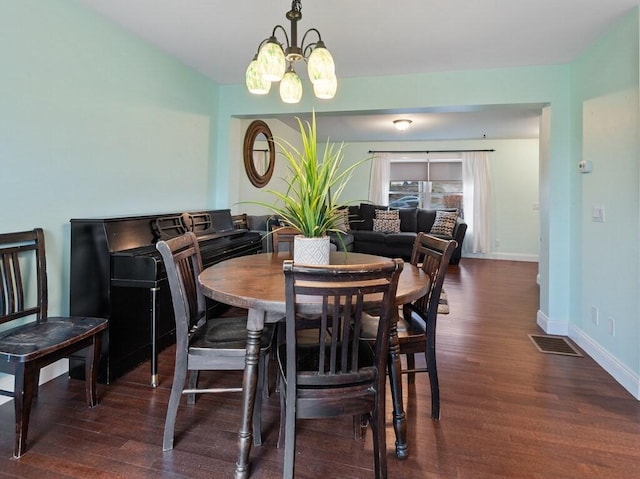 dining area featuring a notable chandelier and dark wood-type flooring