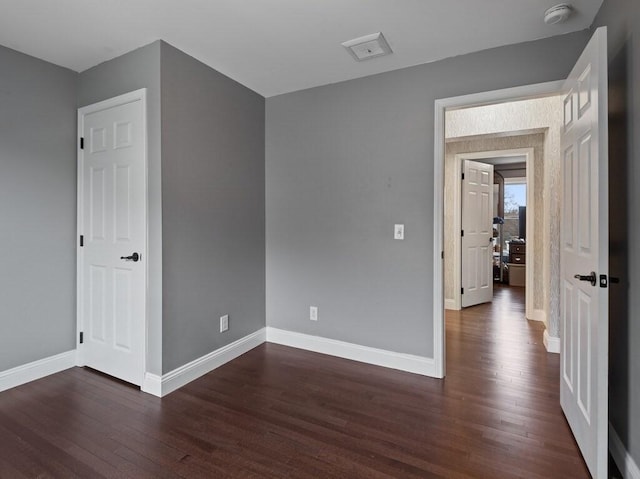 empty room with dark hardwood / wood-style flooring