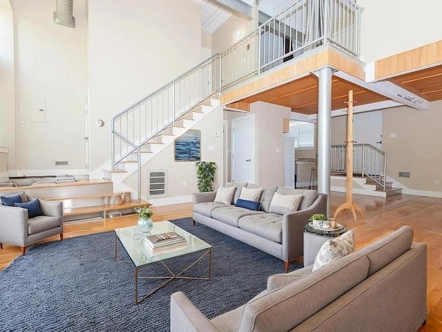 155 Brookline Unit 2, Cambridge, MA 02139 - living area with stairway, a high ceiling, wood finished floors, and baseboards