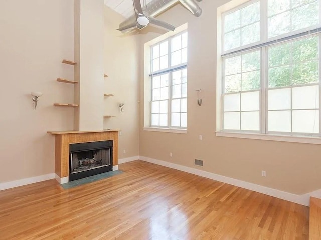 155 Brookline Unit 2, Cambridge, MA 02139 - unfurnished living room with a tiled fireplace, baseboards, light wood-style flooring, and ceiling fan