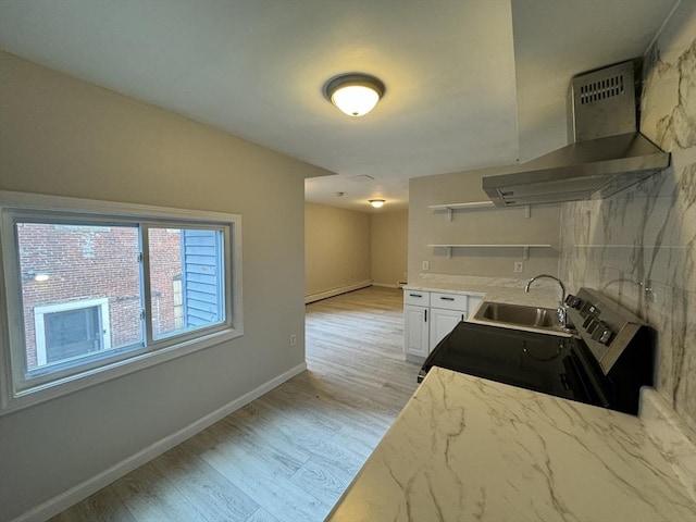 kitchen with open shelves, electric range, a sink, light wood-type flooring, and wall chimney exhaust hood