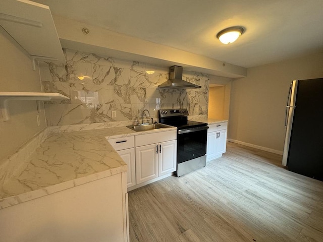 kitchen with light wood-style floors, appliances with stainless steel finishes, wall chimney range hood, white cabinetry, and a sink