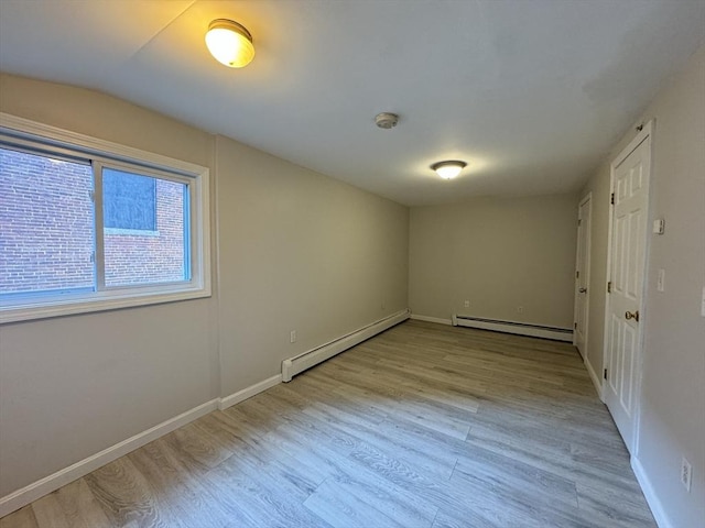 interior space with a baseboard radiator, baseboards, baseboard heating, and wood finished floors